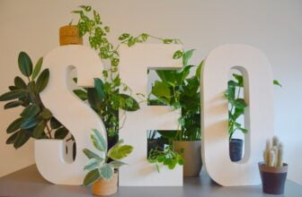 SEO white sign with plants and a potted plant next to it