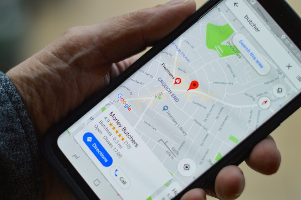 person holding smartphone looking at google maps business listing
